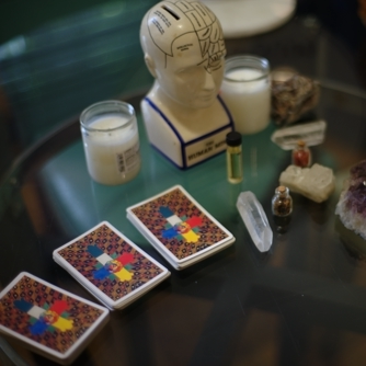 Psychic Reading table setup with Tarot Cards, crystals, candles and blessed oils.